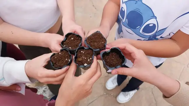 Chavales sujetando semilleros